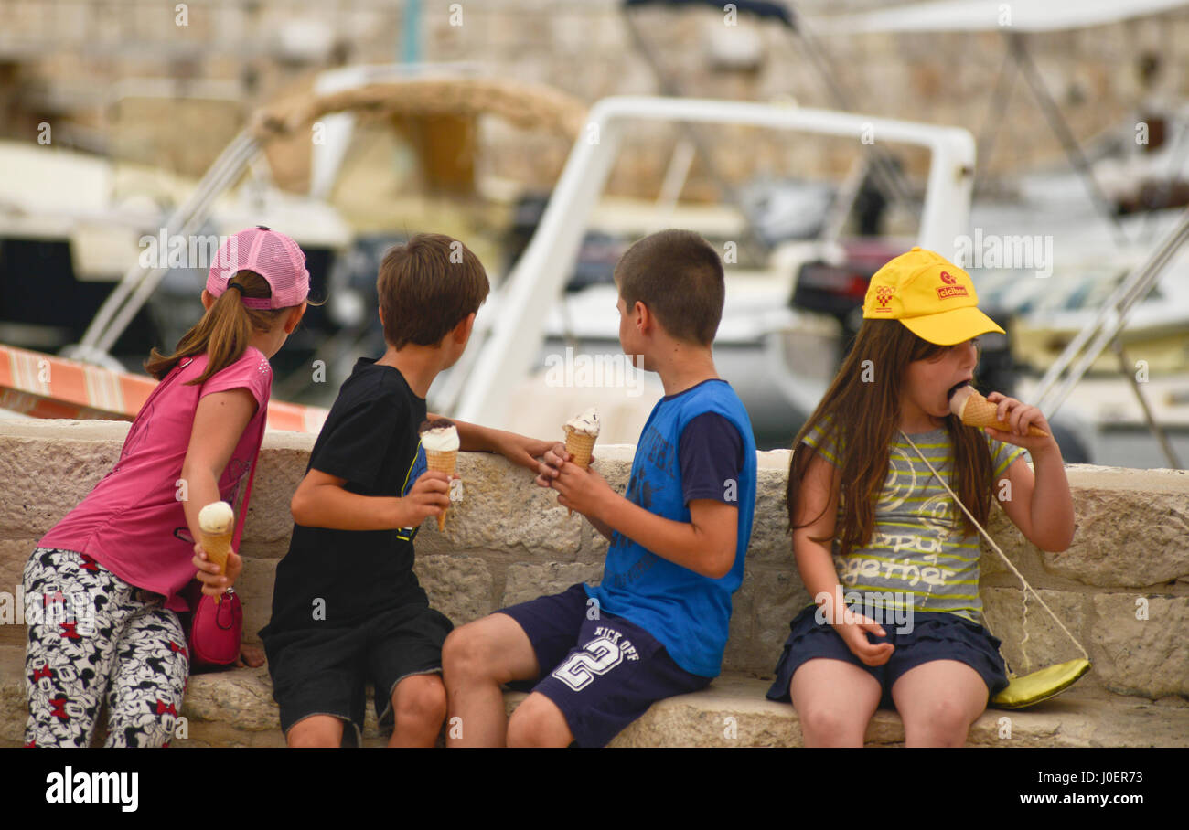 A scuola i bambini a mangiare il gelato durante un'escursione. La citta di Hvar, Croazia Foto Stock
