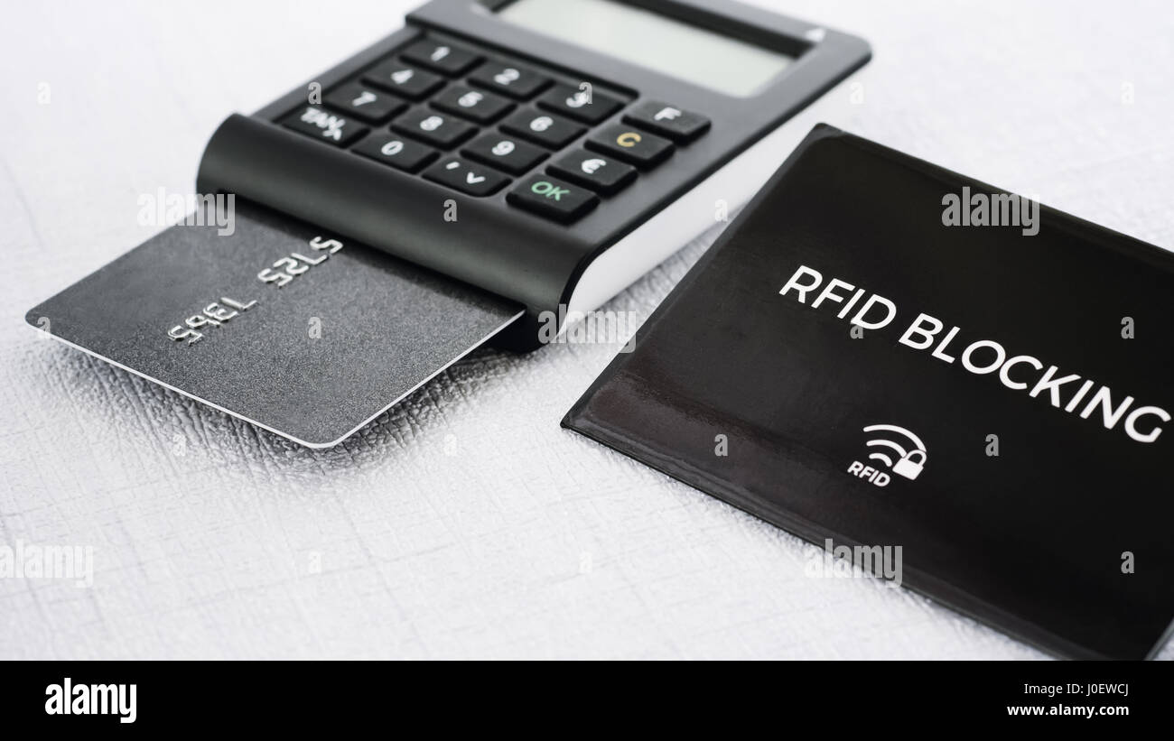Colore nero protezione RFID manicotto per la carta di credito sicura da hacking davanti e tan generatore con carta di credito in esso sulla terra di mezzo Foto Stock
