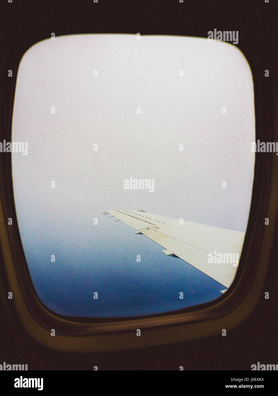 Close-up del velivolo finestra con vista su una gamma di montagne Foto Stock