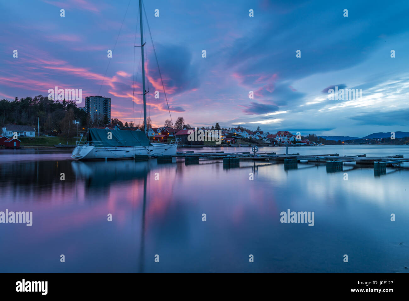 Tramonto sul dock, porto e le barche, riflette le nuvole colorate in acqua di fiume 2 - Porsgrunn, Norvegia Foto Stock