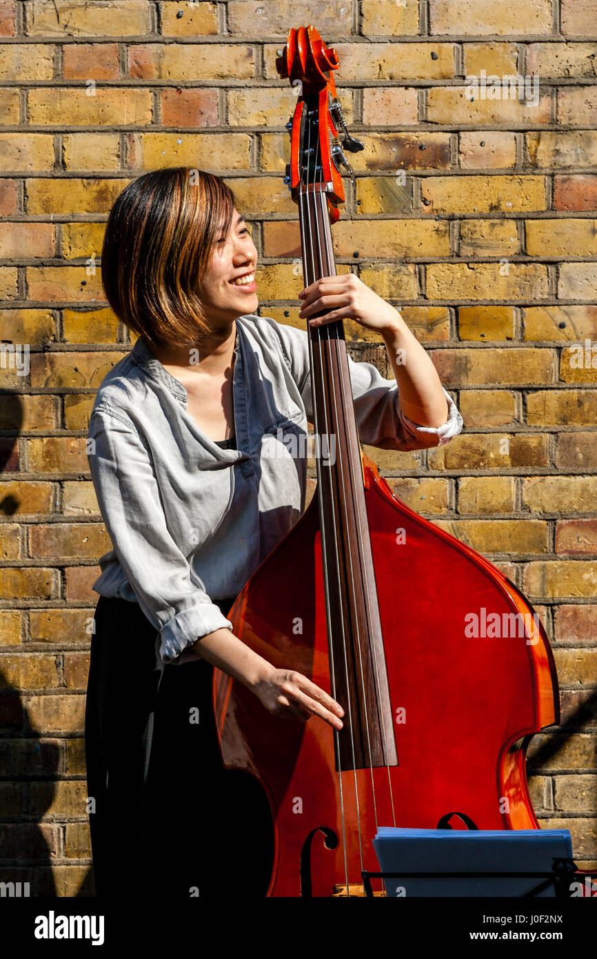 Una giovane donna musicista suonava in Brick Lane, Londra, Inghilterra Foto Stock