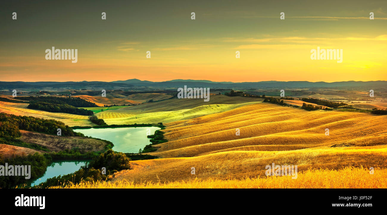 Toscana, Crete Senesi Paesaggio vicino Siena, Italia, Europa. Piccolo lago verde e i campi gialli, cielo blu con nuvole. Foto Stock