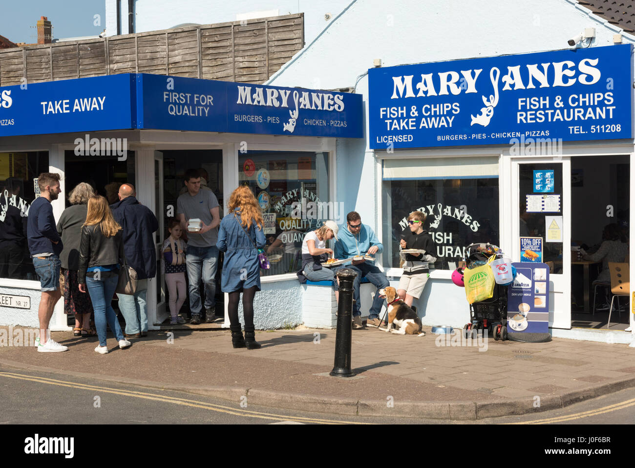 Persone mangiare pesce e patatine al di fuori di Mary Jane è il pesce e il chip shop in Cromer NORFOLK REGNO UNITO Foto Stock