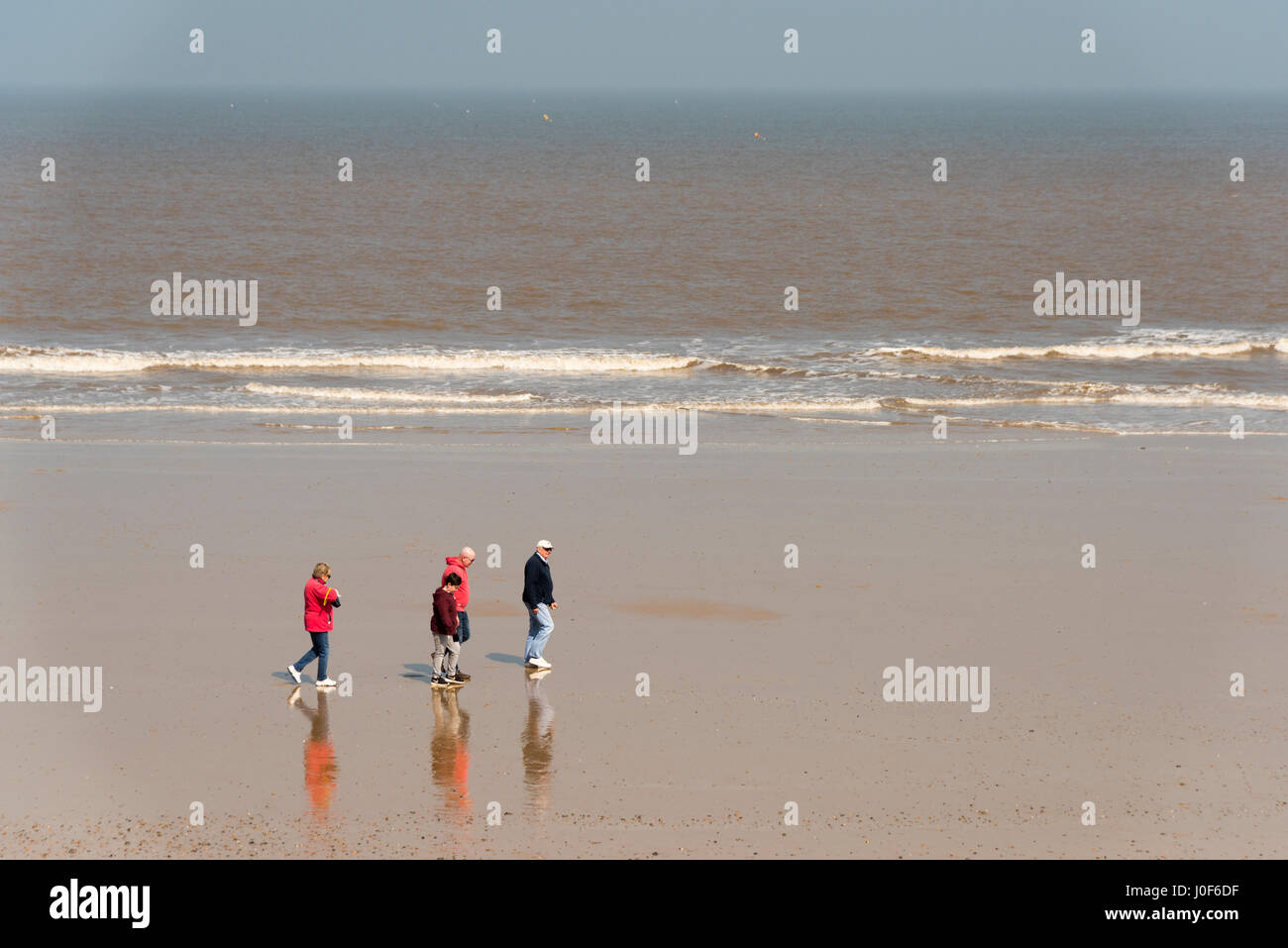 Una famiglia a camminare su una spiaggia a Cromer NORFOLK REGNO UNITO DAL MARE DEL NORD Foto Stock