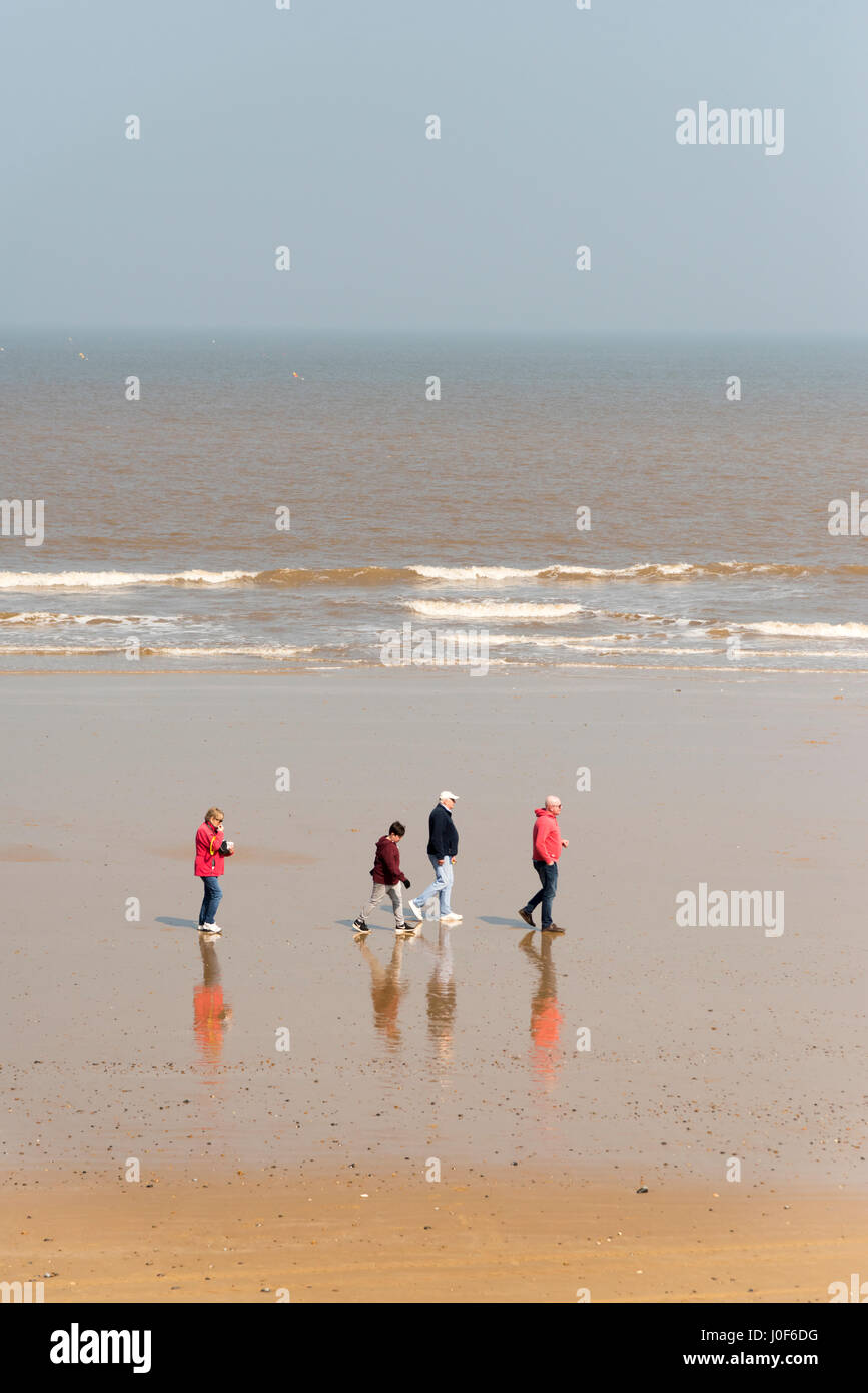 Una famiglia a camminare su una spiaggia a Cromer NORFOLK REGNO UNITO DAL MARE DEL NORD Foto Stock