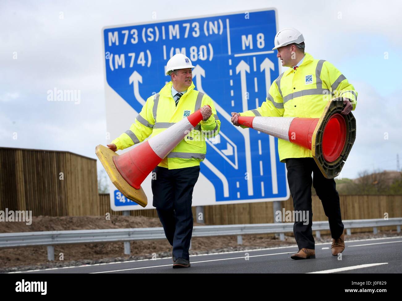 Economia e le infrastrutture Segretario Keith Brown (sinistra) e Trasporti Scozia Project Manager Graeme Reid sulla nuova sezione sull'autostrada M8 nei pressi di Ballieston, North Lanarkshire, che è aperta al traffico quasi una settimana di anticipo. Foto Stock