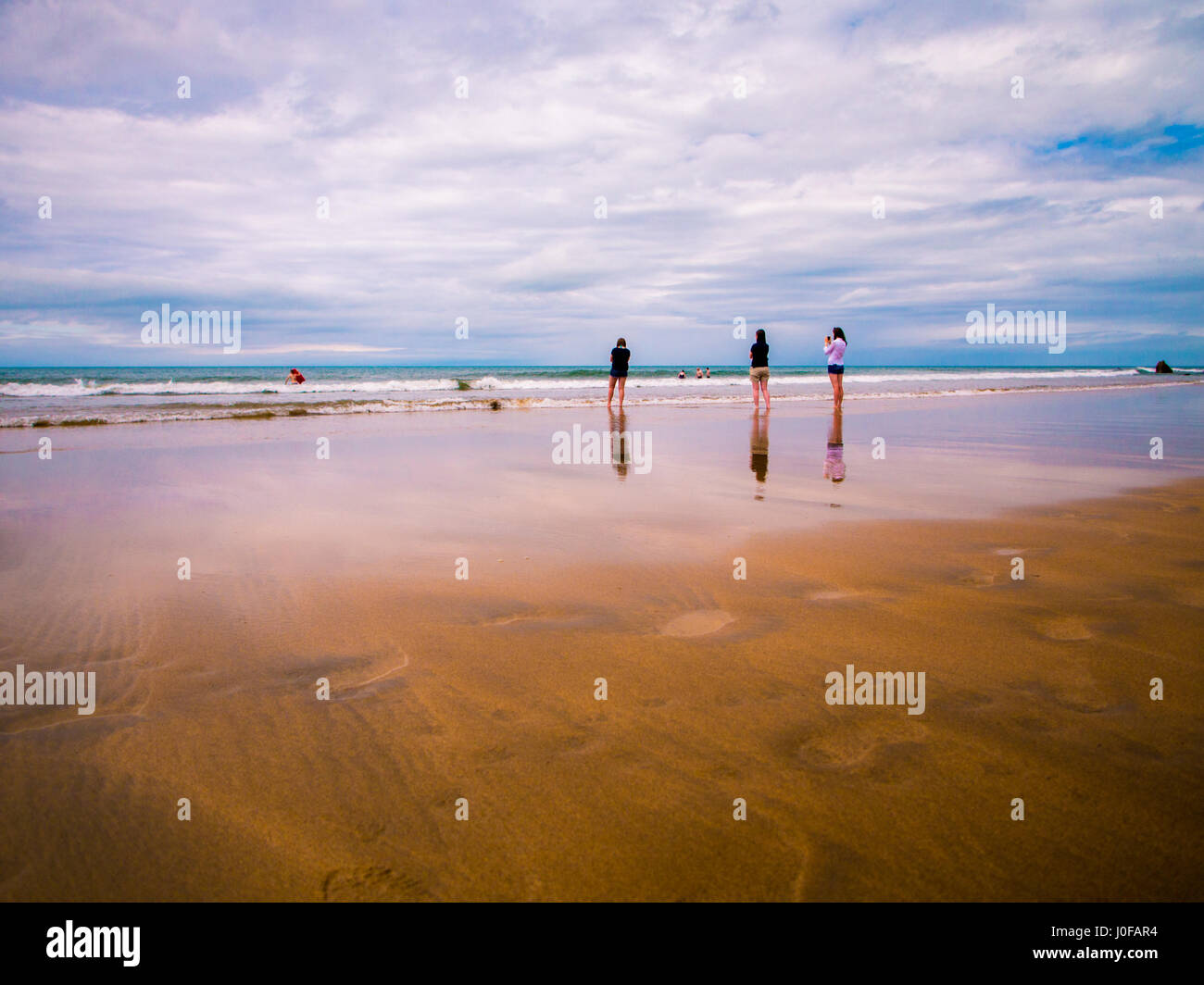 Il Cornish litorale durante il periodo estivo in Inghilterra con un piccolo gruppo di persone sulla spiaggia Foto Stock