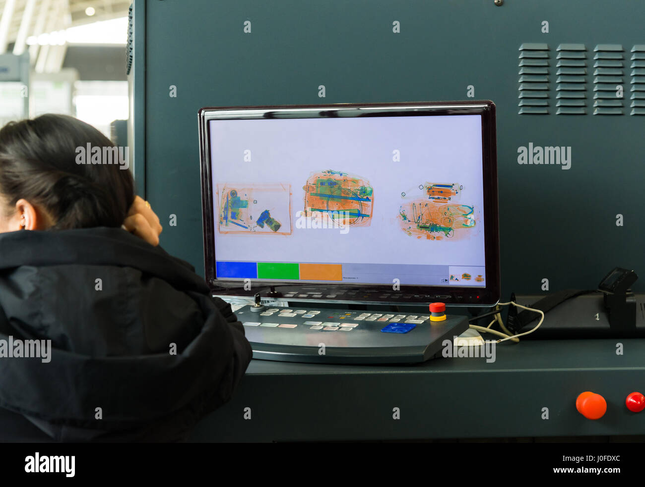 Un X-ray monitor all aeroporto e donna dal servizio di sicurezza. Foto Stock
