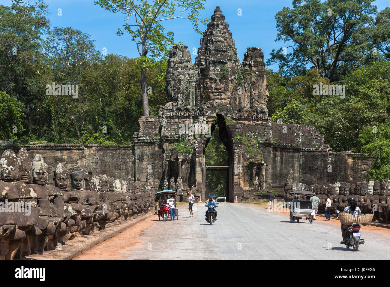 Angkor Thom South Gate, l'entrata alla città antica, con deva e asura statue su ciascun lato della strada rialzata Foto Stock