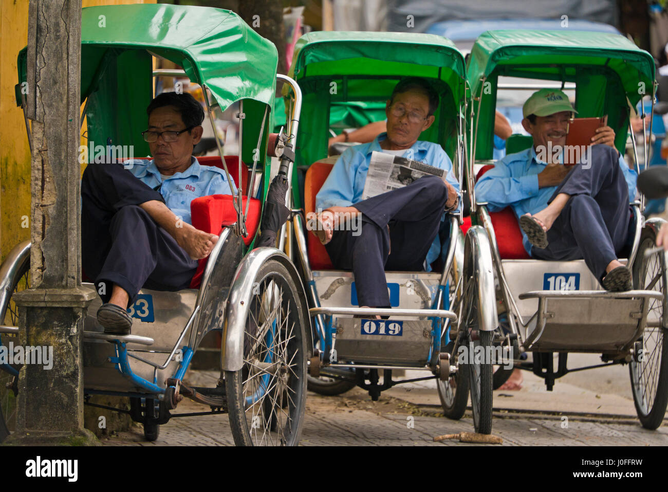 Vista orizzontale di driver cyclo leggere diverse cose in Hoi An, Vietnam. Foto Stock