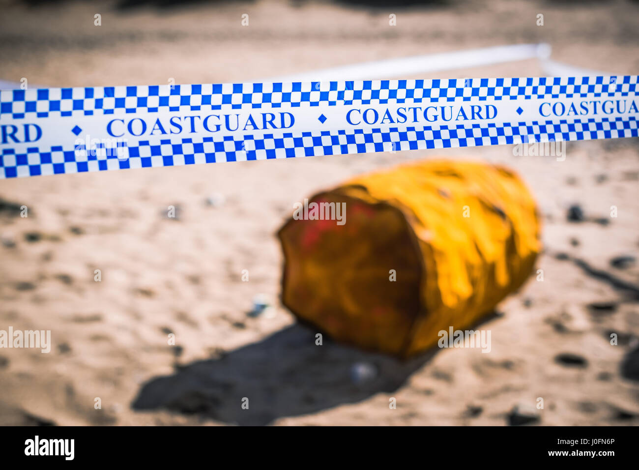 Vecchio arrugginito perde olio tamburo cordoned fuori dalla guardia costiera dopo il lavaggio fino a Bude sul litorale britannico durante una tempesta la notte prima di Foto Stock