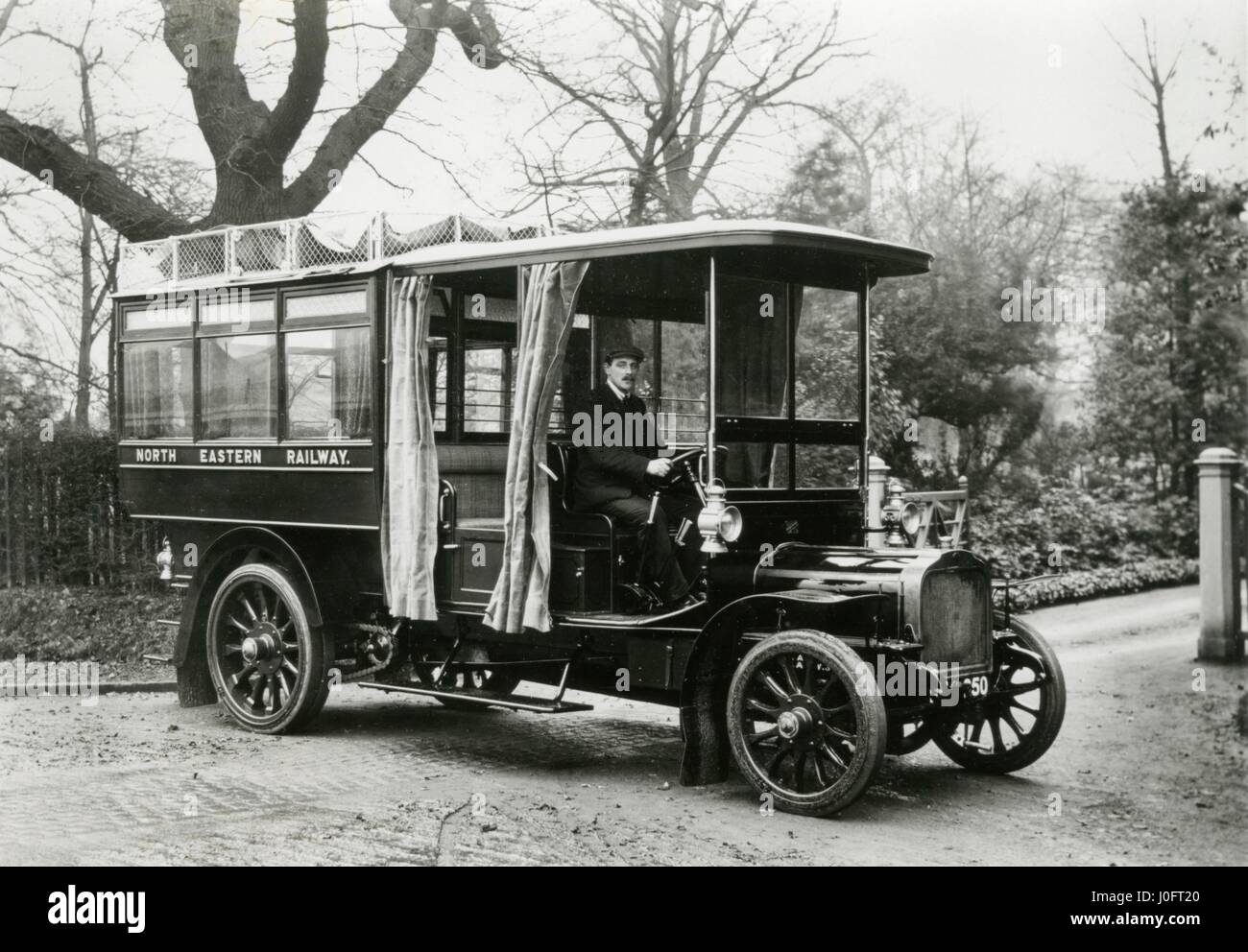 Un uomo seduto al volante di un motore omnibus su un telaio Saurer, vista laterale Foto Stock