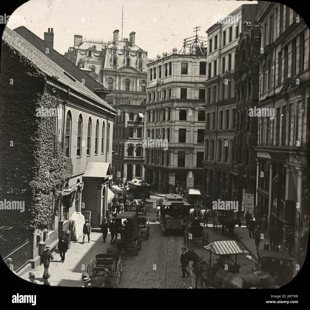 Strada trafficata scena, con persone, tram, cavalli e carri Foto Stock