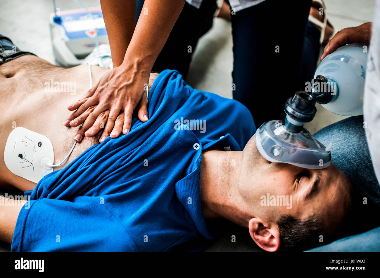 Una ragazza aiutando un ragazzo dopo un attacco di cuore con la rianimazione cardiopolmonare Foto Stock