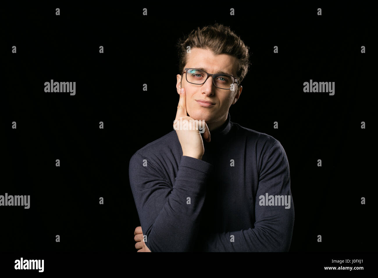 Smart uomo con eleganti occhiali e collo camicetta su sfondo nero Foto Stock