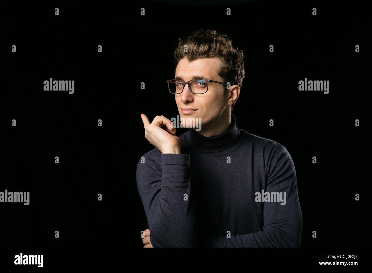 Smart uomo con eleganti occhiali e collo camicetta su sfondo nero Foto Stock