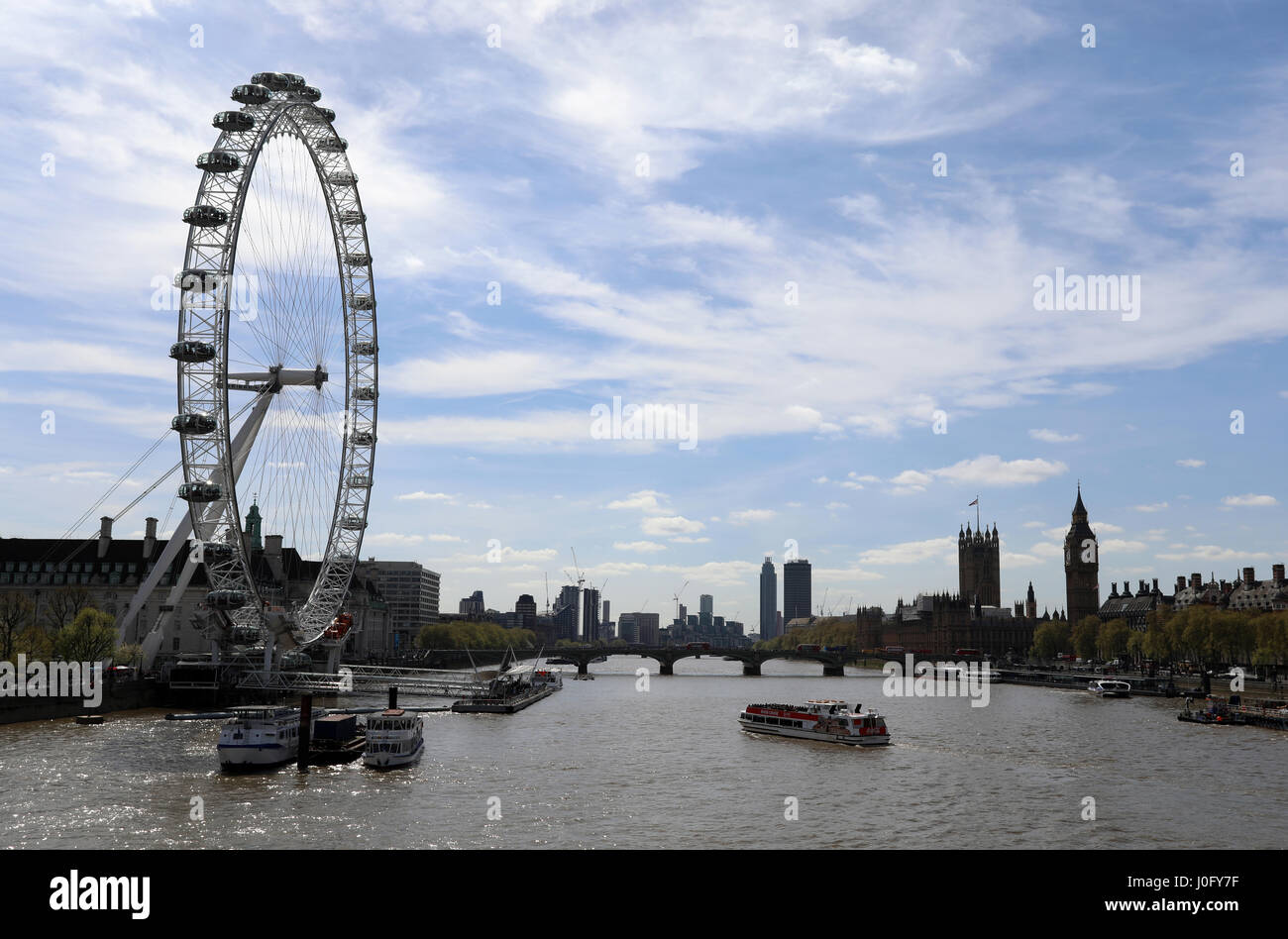 Il London Eye ruota panoramica si affaccia sul Fiume Tamigi nel centro di Londra, con il Palazzo di Westminster in background. Foto Stock