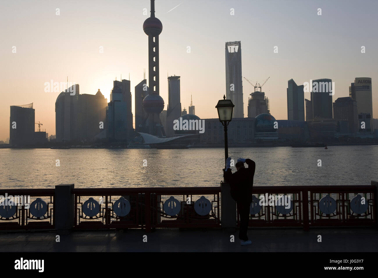 L'uomo facendo esercizi del mattino & vista di Pudong dal Bund, Shanghai, Cina Foto Stock
