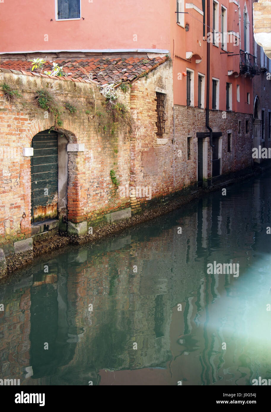 Canale di Venezia in montagna con riflessioni di edifici antichi muri di porte e finestre Foto Stock