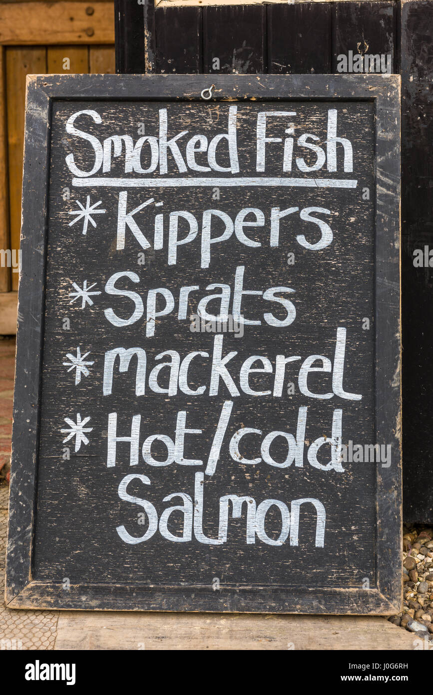 Una lavagna mostra una gamma di pesce affumicato disponibile per l'acquisto. Foto Stock