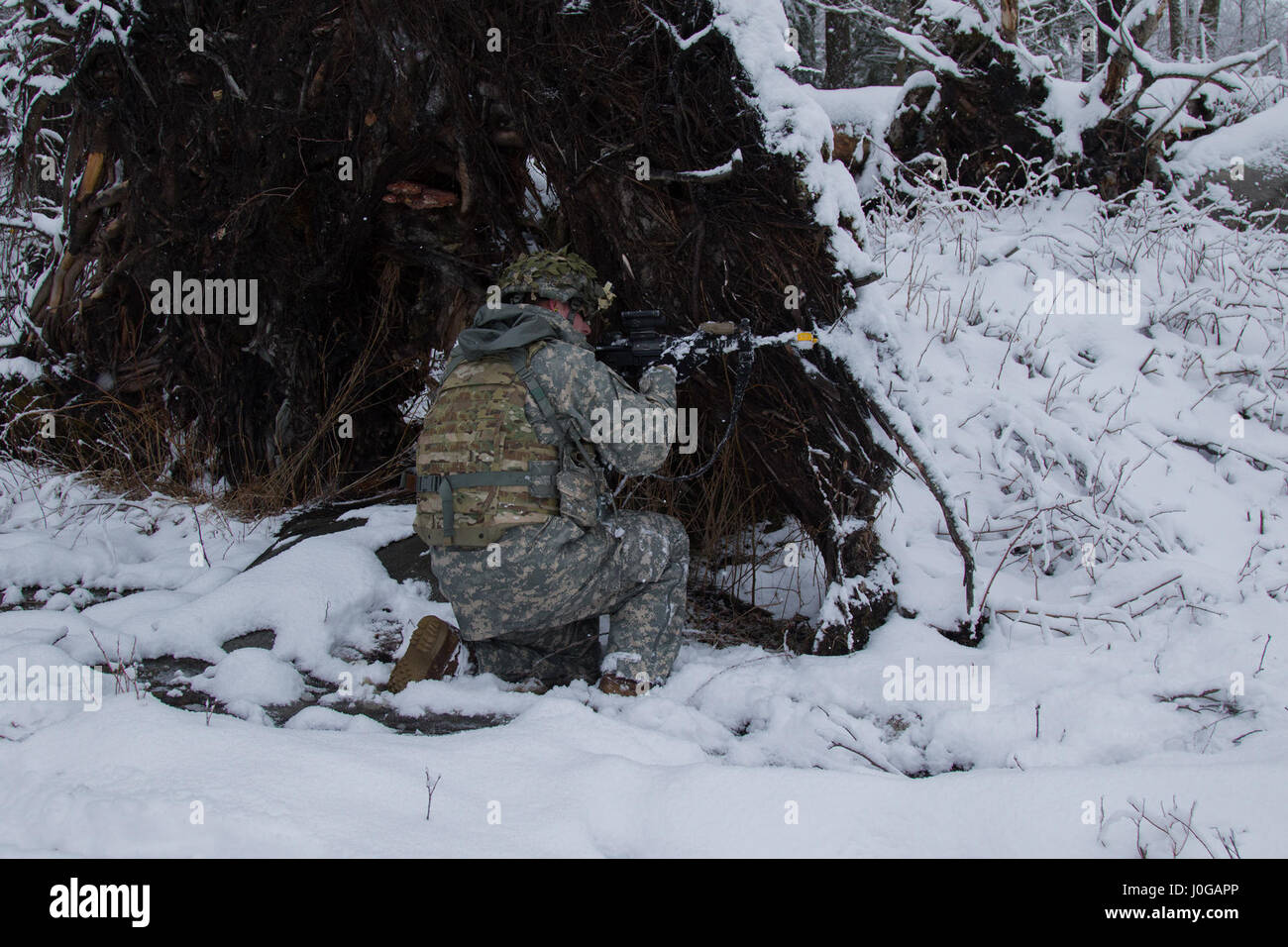 Un soldato con Charlie truppa, 1° Stormo, 172nd reggimento di cavalleria, 86a brigata di fanteria combattere Team (montagna), Vermont Guardia nazionale, prende il coperchio dietro un albero caduto a Camp Ethan Allen Sito di formazione, Gerico, Vt., 8 aprile 2017. Soldati di Charlie truppa condotta una squadra manovra live-fire esercizio durante il trapano per preparare la formazione annuale. (U.S. Esercito nazionale Guard foto di Spc. Avery Cunningham) Foto Stock