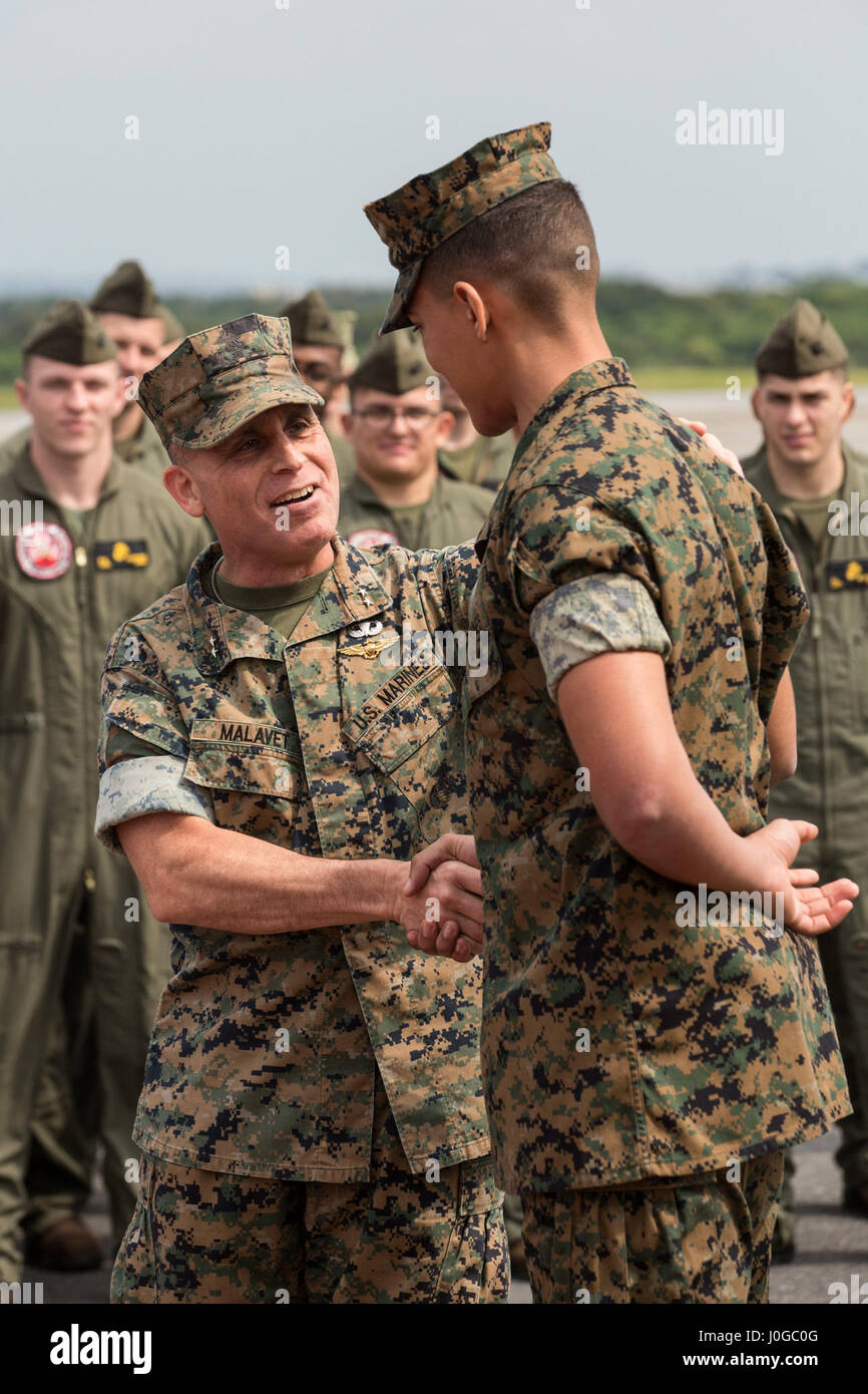 Stati Uniti Marine Corps Il Mag. Gen. Joaquin Malavet, Marine Corps Instillations Pacific comandante generale, scuote le mani con un marine con sede e Sede Squadron (H&SA) dopo la presentazione del 2016 la difesa nazionale Transportation Association (NDTA) unità militari del premio di anno in Marine Corps Air Station Futenma, Okinawa, in Giappone, 29 marzo 2017. H&HS ha ricevuto il premio per le loro prestazioni eccezionali e servizio esemplare nel campo del trasporto e della logistica. (U.S. Marine Corps photo by MCIPAC combattere lancia fotocamera Cpl. Christian J. Robertson) Foto Stock