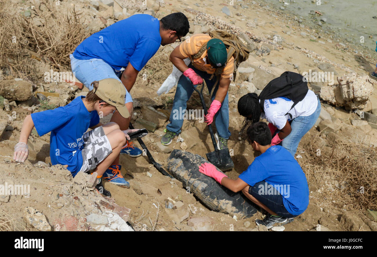 Boy Scout da truppa 938 e U.S. Soldati da Camp Arifjan, Kuwait, scavare un vecchio pneumatico fuori della sabbia sulla spiaggia Sulaibikhat, Kuwait, durante l'ultimo pulito-ing dello sforzo per l'anno con il Kuwait Società per la protezione degli animali e del loro Habitat, 1 aprile. La truppa lavora al fianco di altri americani e cittadini kuwaitiani per aiutare a preservare la spiaggia. (U.S. Esercito foto di Sgt. Betania Huff, ARCENT Affari pubblici) Foto Stock