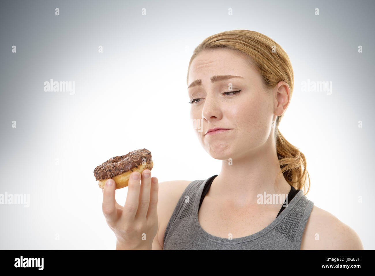 Donna fitness sicuri se lei dovrebbe mangiare una ciambella Foto Stock