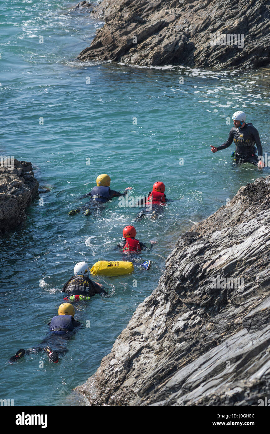 Avventura Coasteering rocce mare zona intercotidale avventura robusto istruttore di nuoto attività fisica sforzo fisico costiere della costa Foto Stock
