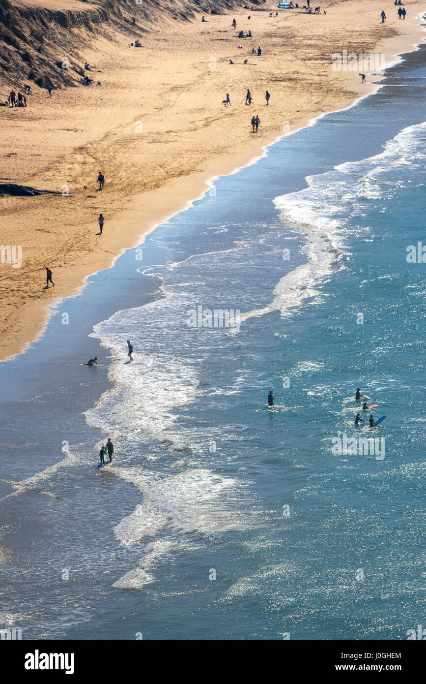 Mare Crantock Beach sabbia di mare vacanzieri sagome stagliano persone figure Shore litorale sera Turismo Foto Stock