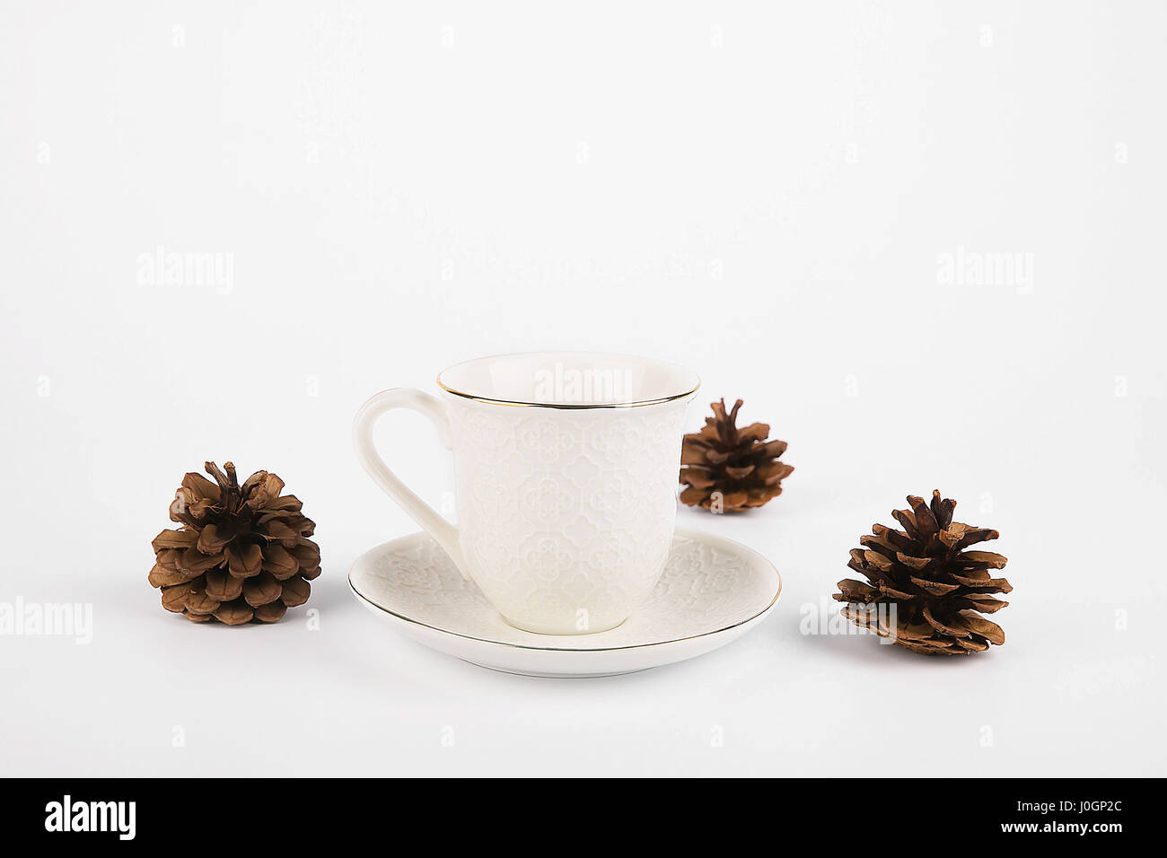 Tazza di tè con cono di pini isolati su sfondo bianco Foto Stock