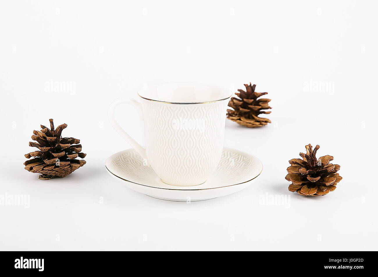 Tazza di tè con cono di pini isolati su sfondo bianco Foto Stock