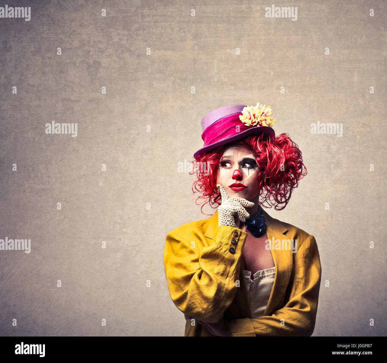 Clown donna pensando all'interno Foto Stock