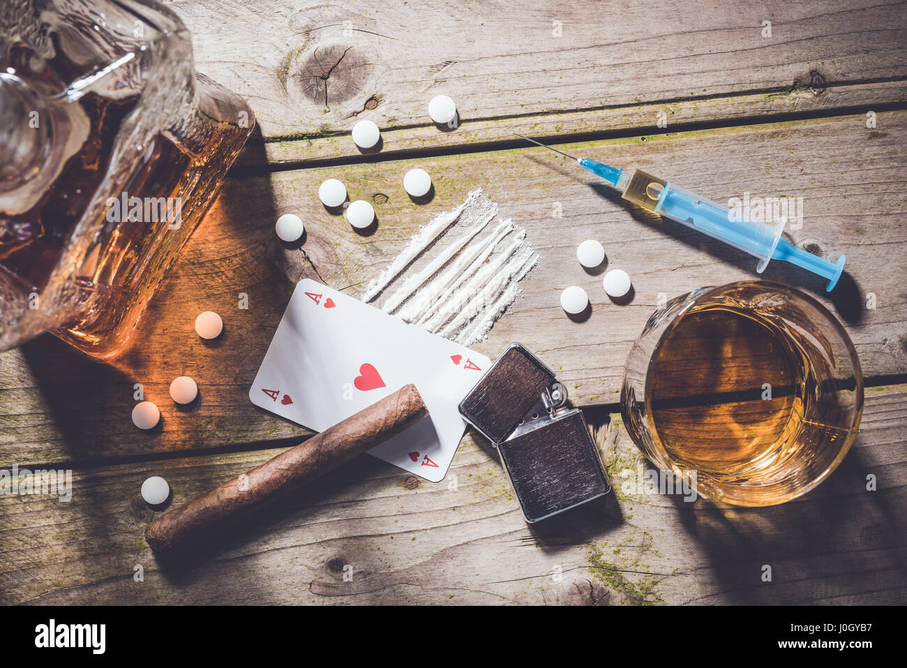 Tettuccio di colpo di droghe e alcol su un tavolo di legno. Concetto di dipendenza Foto Stock