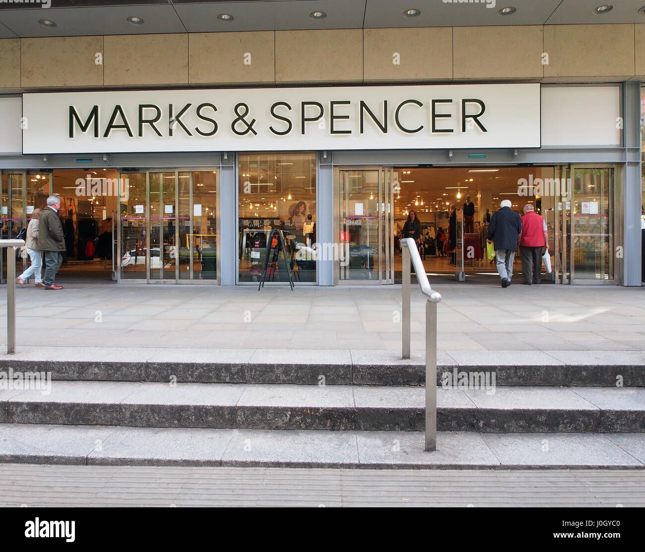 Esterno del Manchester City center shop negozi Marks & Spencer, con coppia maschio e femmina i clienti che entrano e lasciano il negozio. Foto Stock