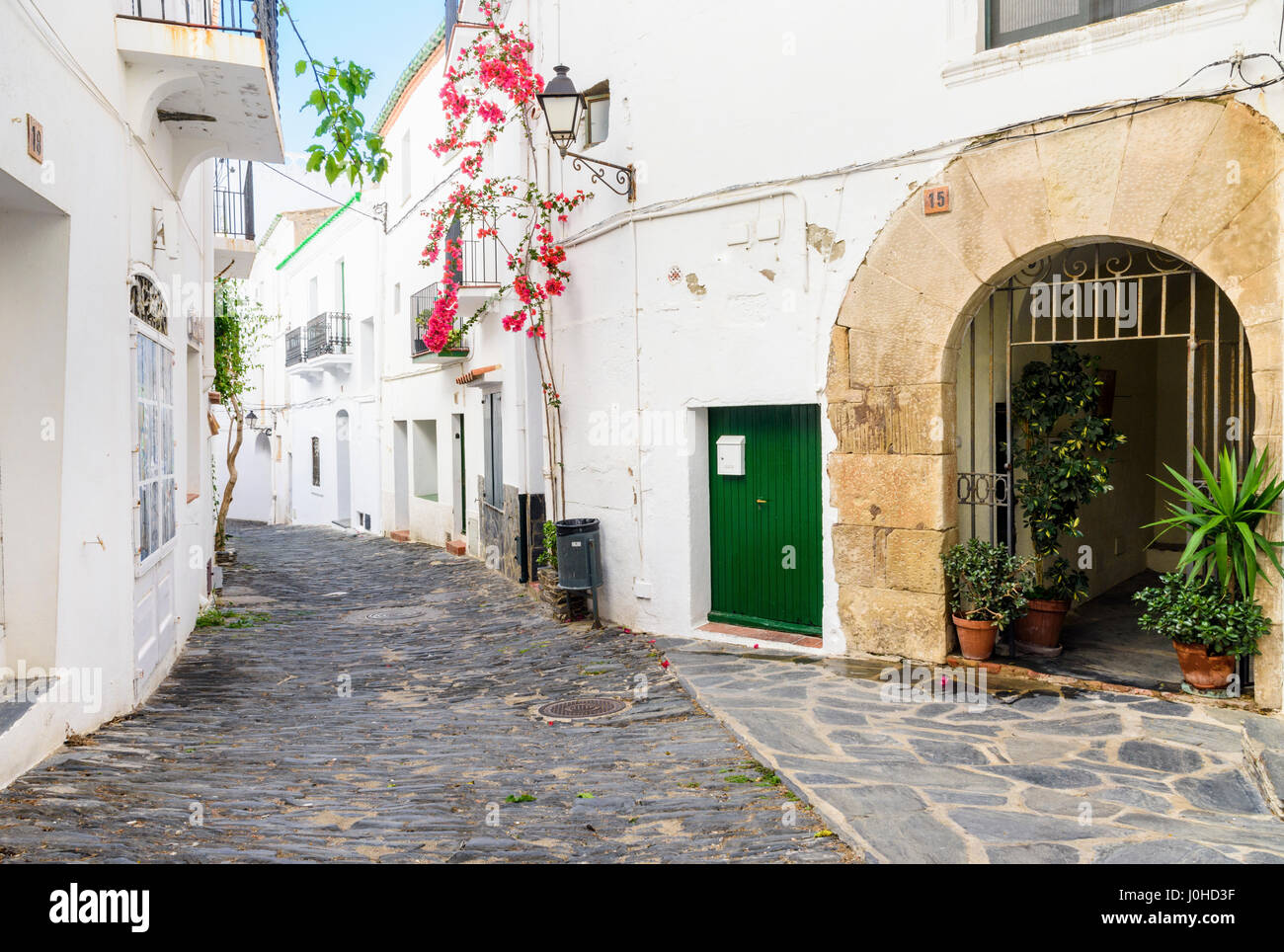 Dipinto di bianco coperto di bougainvillea edifici e città vecchia selciati della città di Cadaques, Costa Brava, Spagna Foto Stock