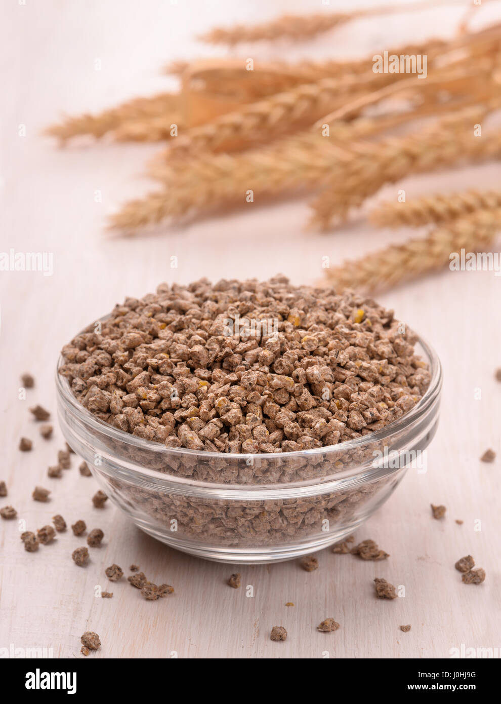 Ciotola di pellettizzate mangime composto su uno sfondo di legno Foto Stock