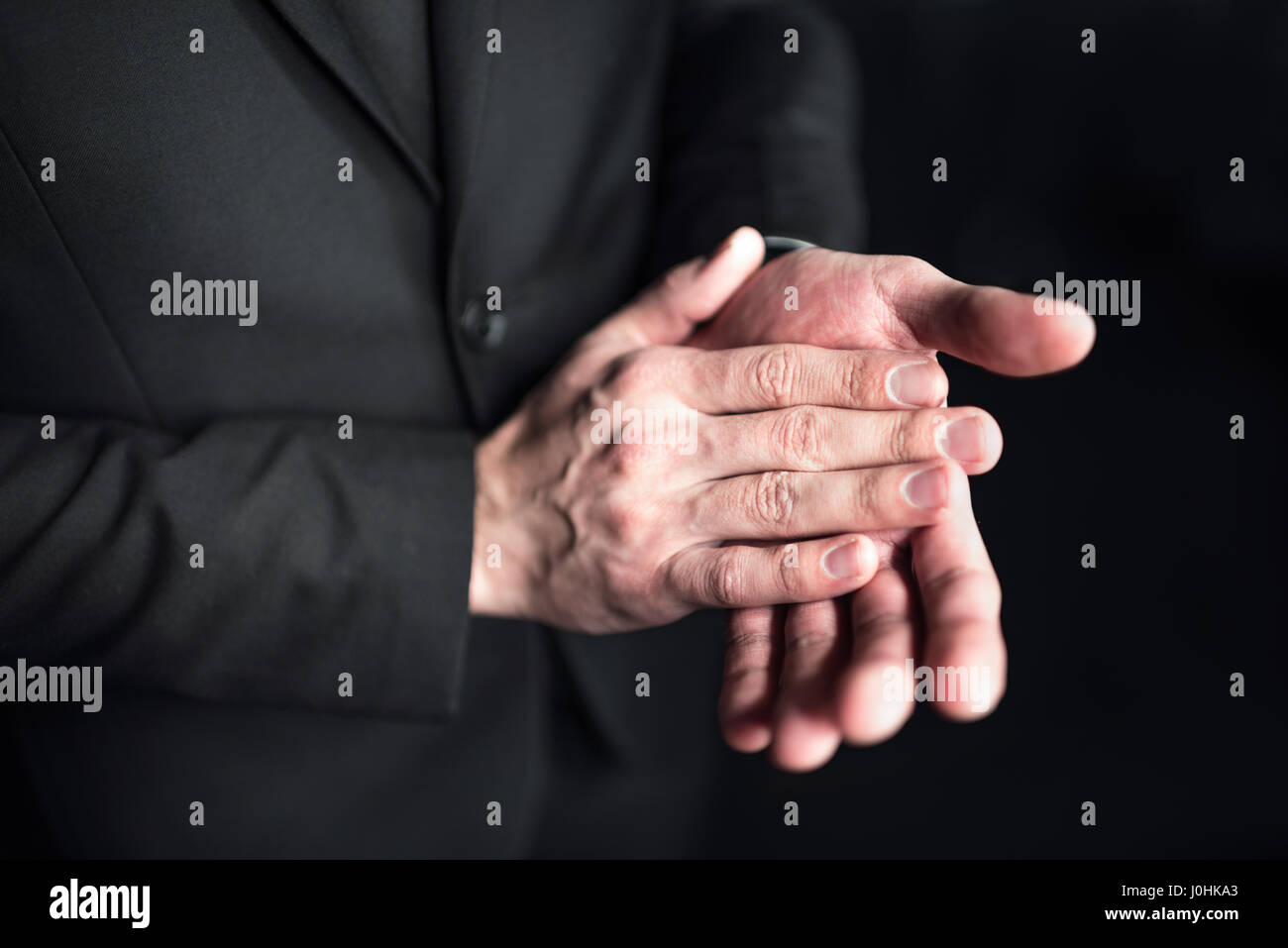 Close-up vista parziale di imprenditore battendo le mani su nero Foto Stock