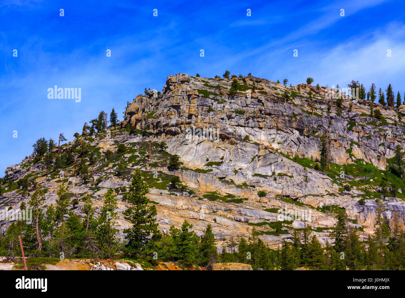 Roccia di granito con formazione di colore giallognolo e cielo blu. Foto Stock