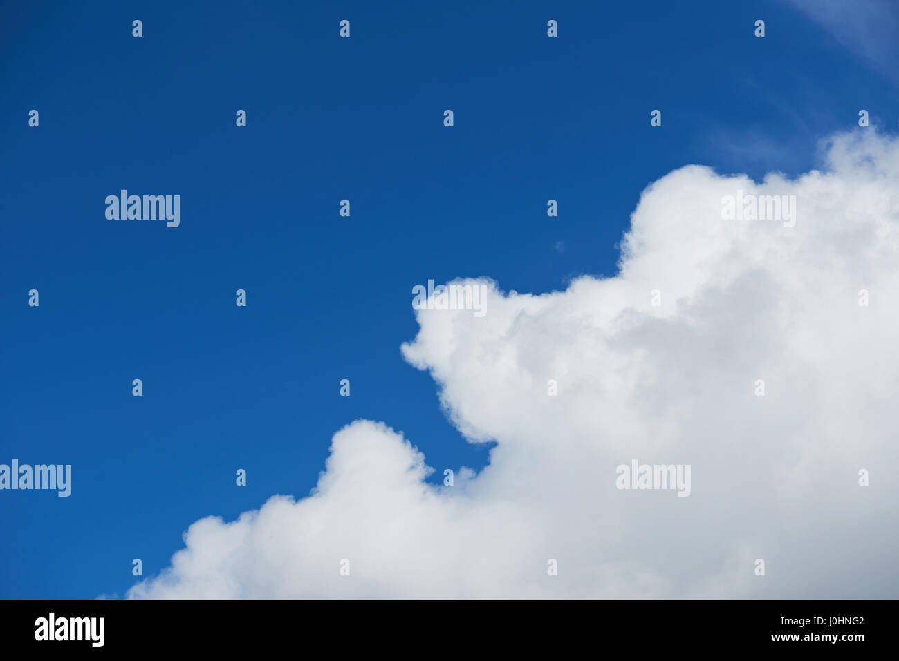Una grande nuvola sul profondo cielo blu cielo sfondo Foto Stock