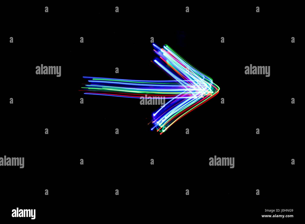 Luce fotografia pittura, una lunga esposizione foto di fairy luci - profilo di una freccia colorata su uno sfondo nero. Luce astratta motion. Foto Stock