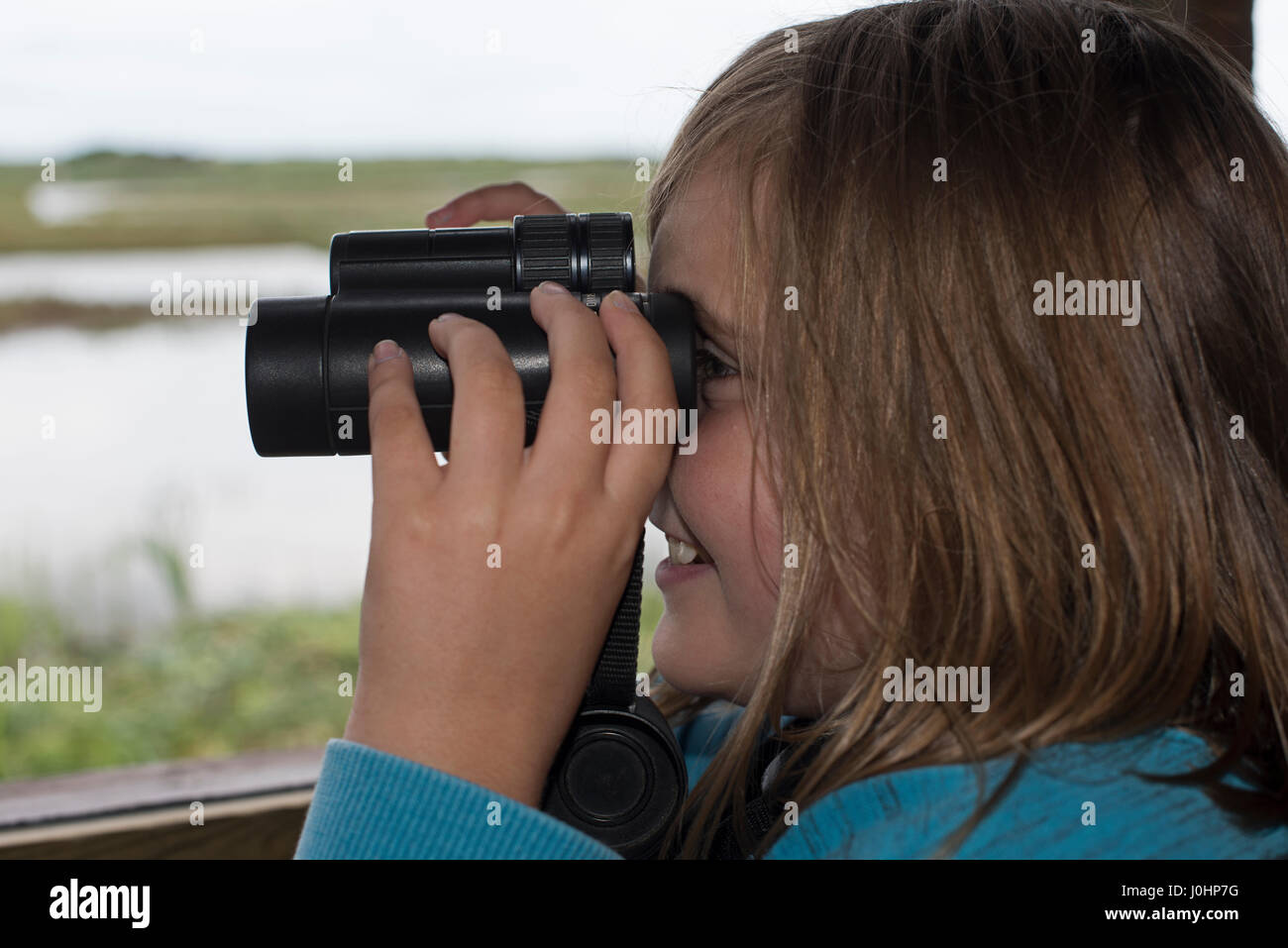 Ragazza giovane (10 anni) per il bird watching a Minsmere RSPB Reserve estate (Modello rilasciato) Foto Stock