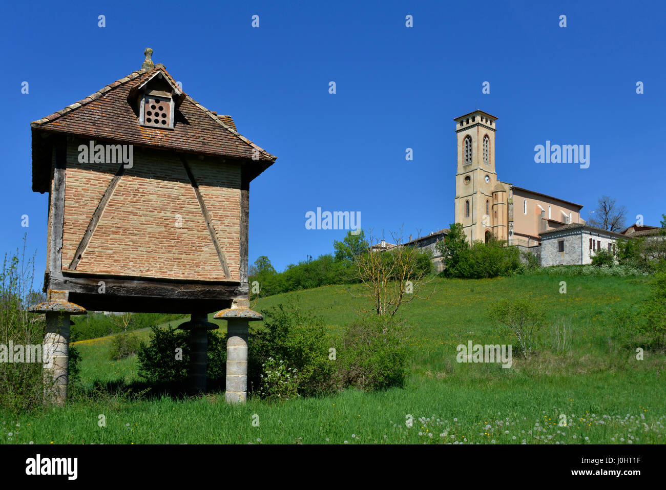 Freestanding pigeonnier e villaggio chiesa a Le Verdier, Occitanie, Francia. Foto Stock