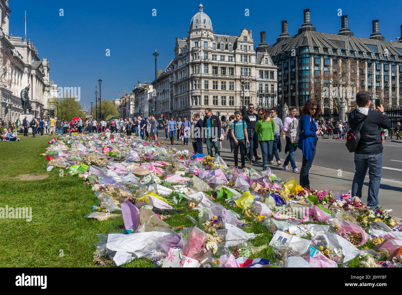 Omaggi floreali, collocati al di fuori del Palazzo di Westminster, alle vittime della Westminster attacco di Khalid Massud che scorreva giù i pedoni sulla West Foto Stock