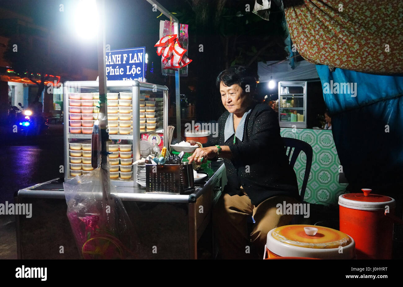 Ho Chi Minh city, Viet Nam, Asia pavimentazione cake shop, Vietnamita donna vendere creme caramel ( flan cake), dolce gustoso cibo durante la notte, Vietnam Foto Stock
