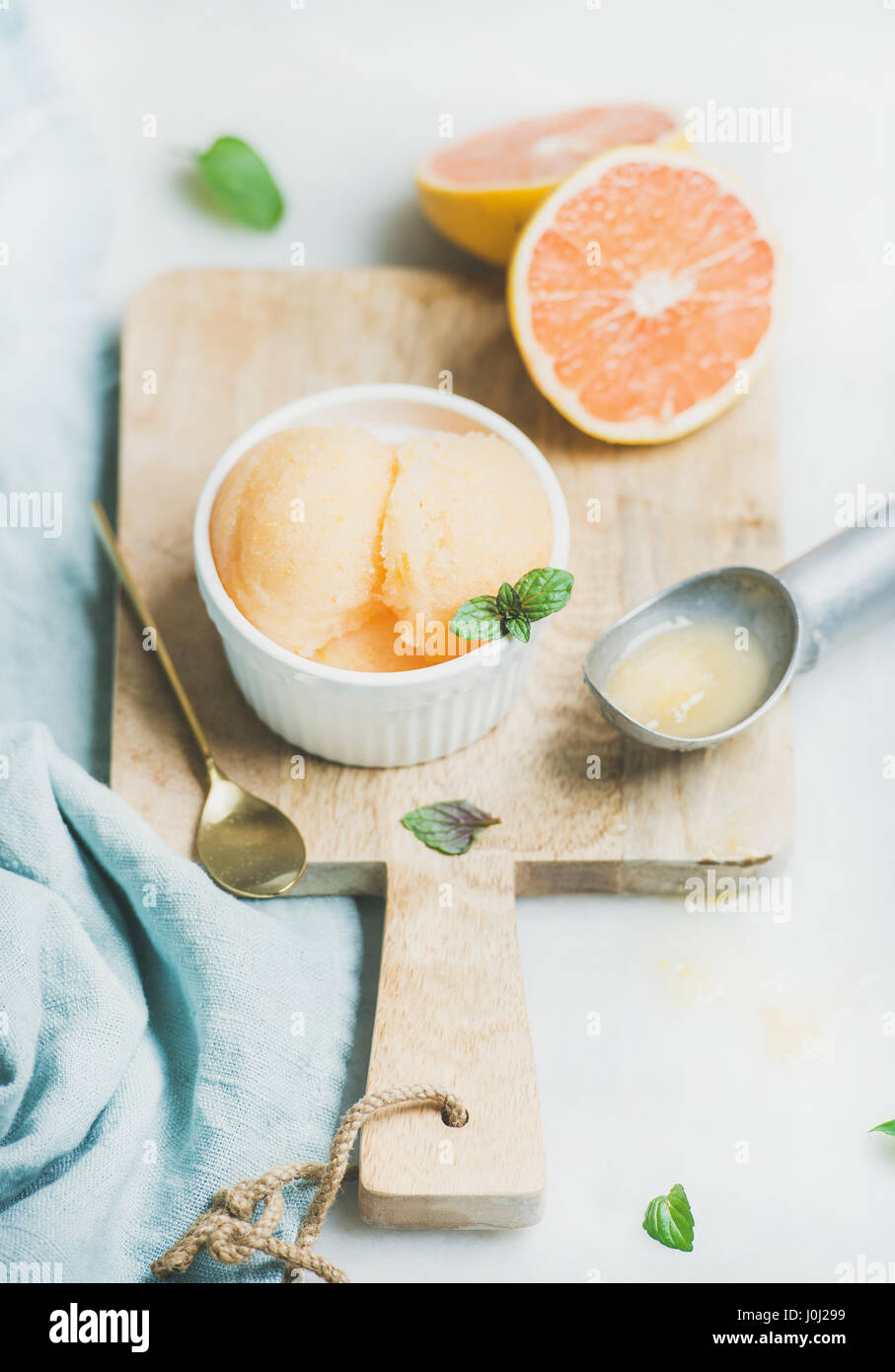 Pompelmo rosa sorbetto con foglie di menta fresca nel recipiente Foto Stock