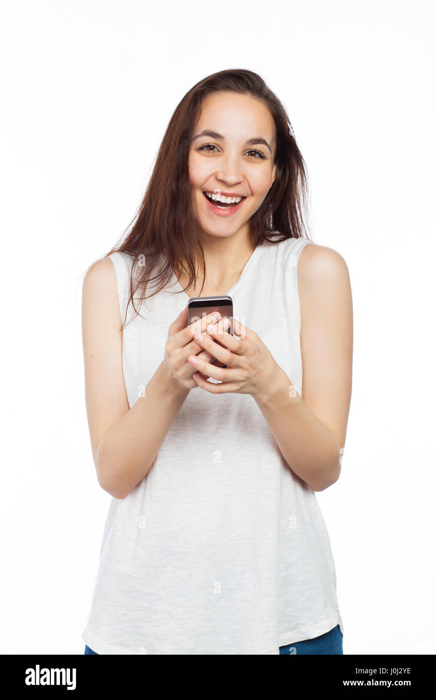 Giovane donna ridere utilizzando il suo telefono, guardando la telecamera, isolato su bianco Foto Stock