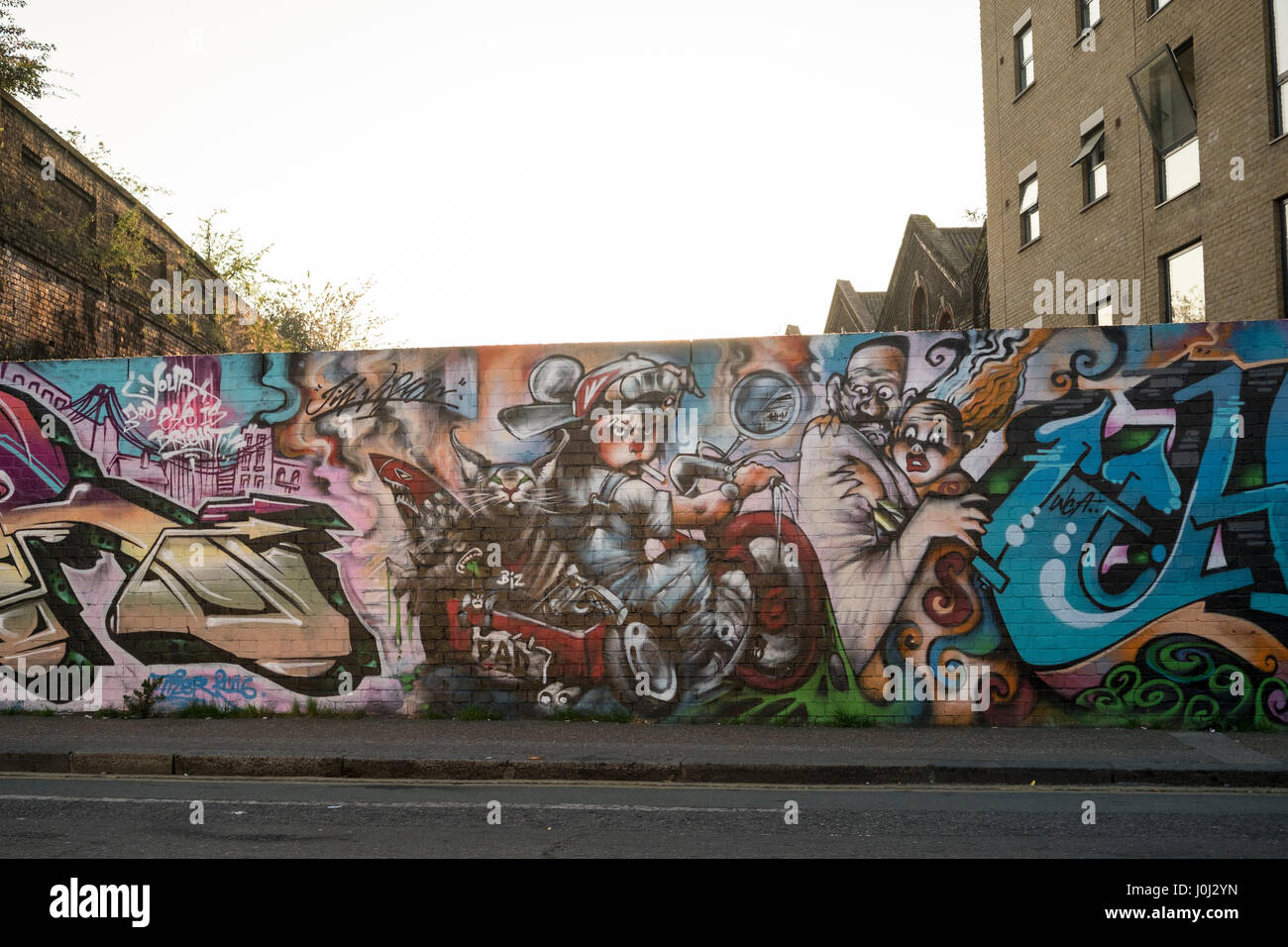 Un mattone giallo parete ricoperta in graffiti intorno al e provenienti zone alla moda di Whitechapel, Bethnal Green e Shoreditch nella zona est di Londra Foto Stock