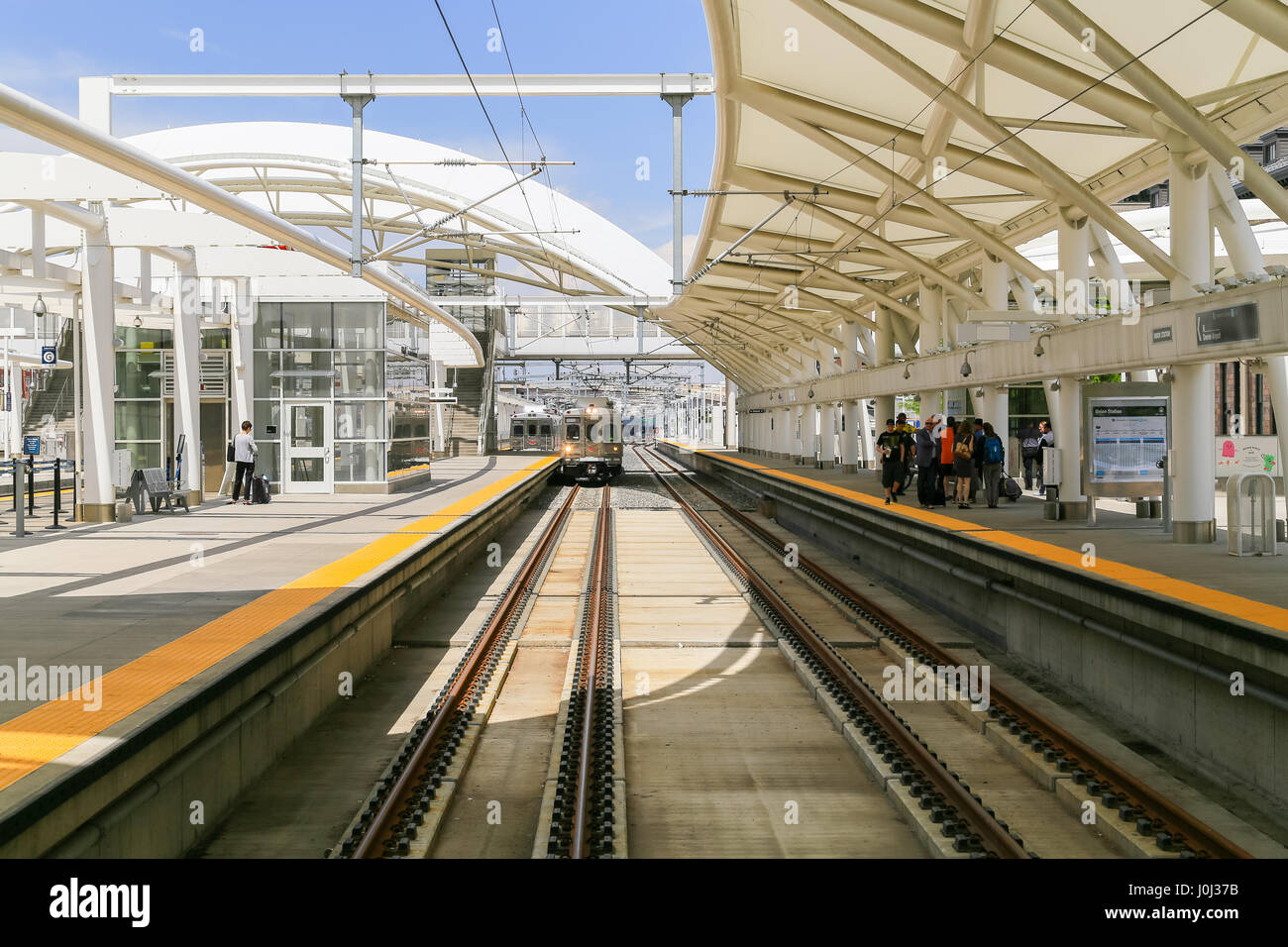 Denver, Stati Uniti d'America - 25 Maggio 2016: treno su uno dei tracciati in aria aperta la sala del treno alla Stazione Union con persone in attesa sulle piattaforme. Foto Stock