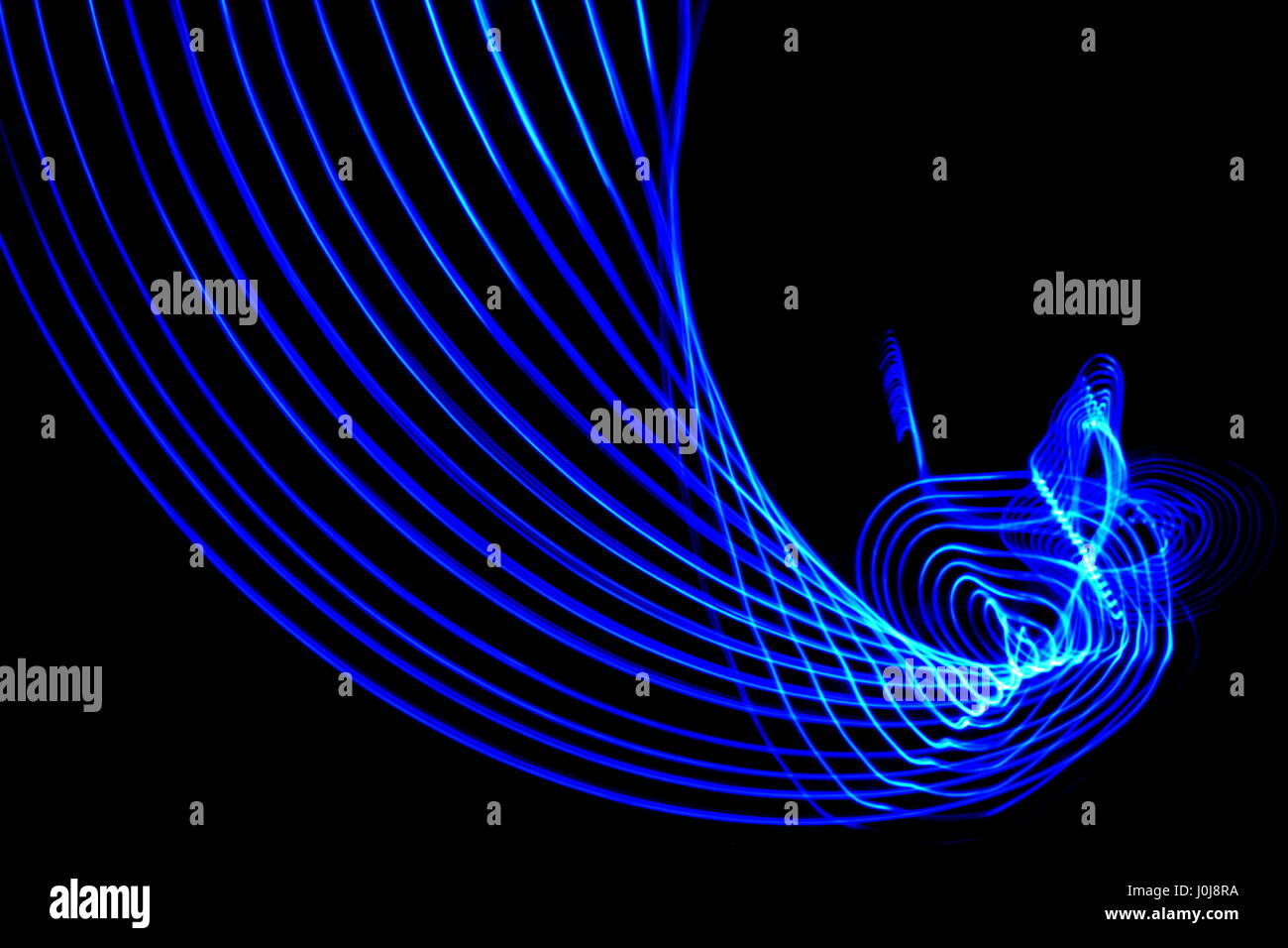 La luce blu fotografia pittura, Swoosh e swirly effetto contro uno sfondo nero Foto Stock